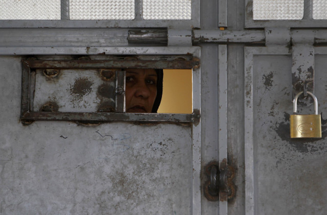 an afghan woman looks out from a viewing panel in a door at herat prison western afghanistan photo reuters an afghan woman looks out from a viewing panel in a door at herat prison western afghanistan photo reuters