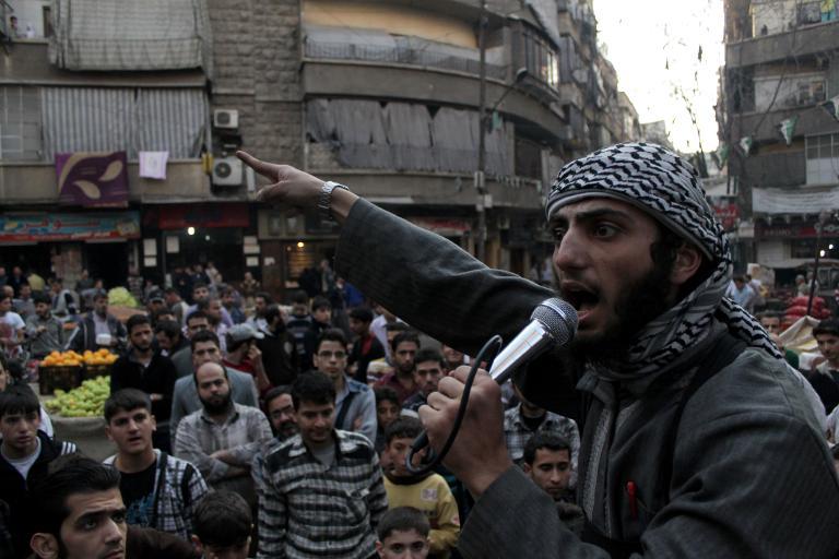 a member of the isil speaks in a microphone in syria urging the local people to struggle against the regime photo afp