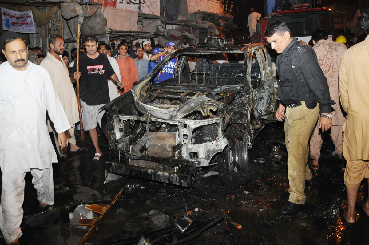 police officials inspect the car of sho shafiq tanoli that was targeted with a bomb on friday evening photo mohammad noman express