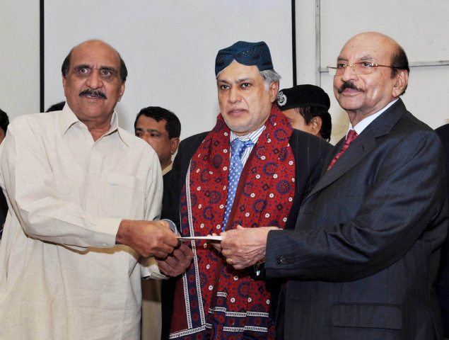 finance minister ishaq dar c along with sindh chief minister qaim ali shah r hand a compensation cheque to an affectee of the violence that resulted in destruction of commercial vehicles photo pid finance minister ishaq dar c along with sindh chief minister qaim ali shah r hand a compensation cheque to an affectee of the violence that resulted in destruction of commercial vehicles photo pid