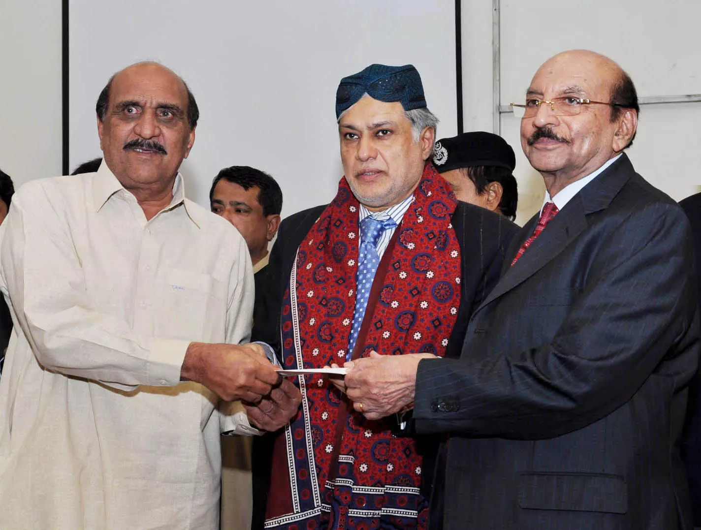 finance minister ishaq dar c along with sindh chief minister qaim ali shah r hand a compensation cheque to an affectee of the violence that resulted in destruction of commercial vehicles photo pid finance minister ishaq dar c along with sindh chief minister qaim ali shah r hand a compensation cheque to an affectee of the violence that resulted in destruction of commercial vehicles photo pid