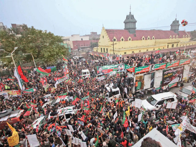 a truck carrying pti and ji leaders makes its way through a crowd of supporters in lahore photo shafiq malik express