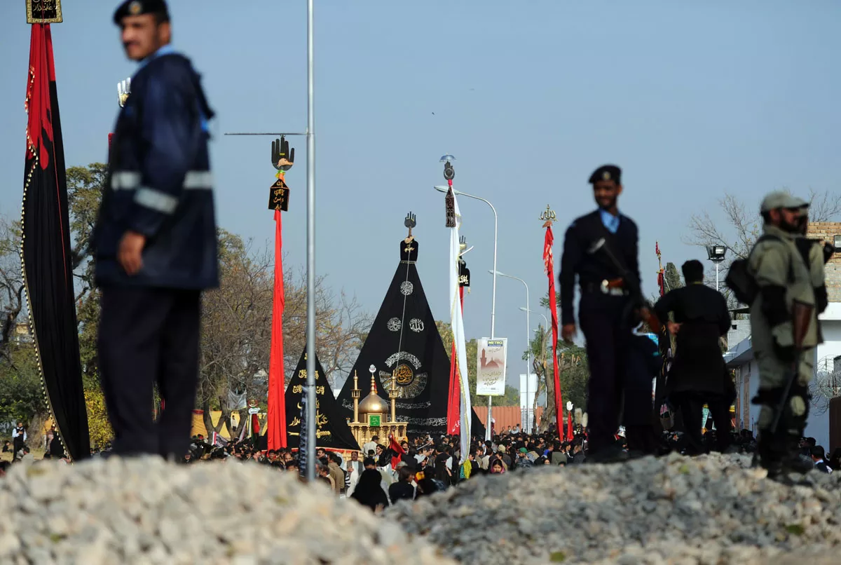 police and military personnel keep watch as mourners take part in a religious procession in islamabad on december 23 2013 photo afp police and military personnel keep watch as mourners take part in a religious procession in islamabad on december 23 2013 photo afp