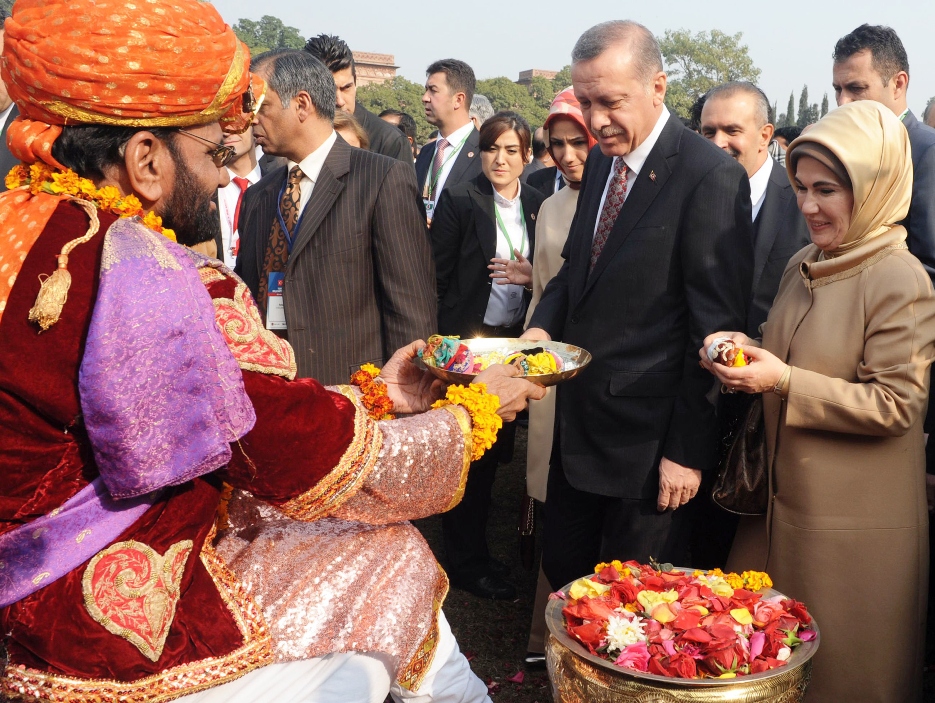 turkish prime minister recep tayyip erdogan 2r and his wife emine erdogan r receive sweets as they arrive at aitchison college in lahore on december 23 2013 photo afp