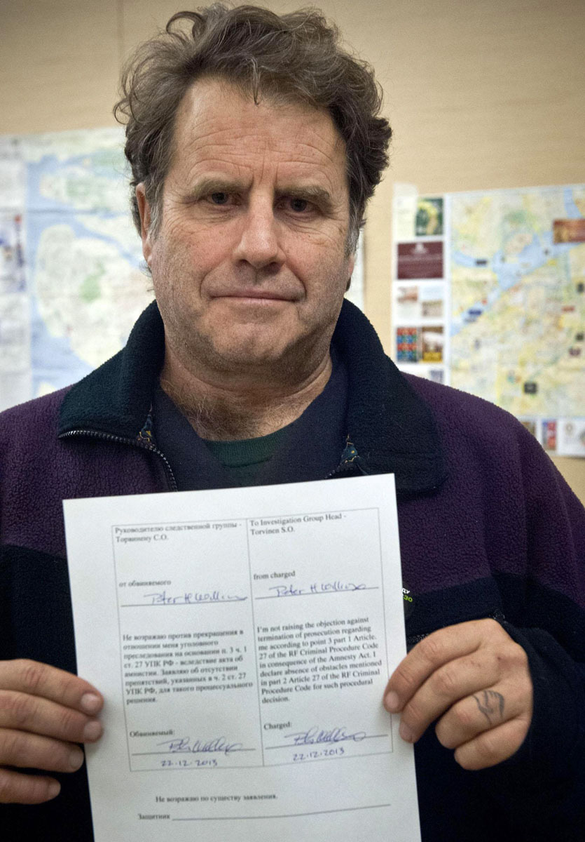 a handout picture taken on december 22 2013 and released by greenpeace international shows the arctic sunrise dutch flagged greenpeace protest ship captain peter willcox from usa holding one of his amnesty documents in st petersburg photo afp