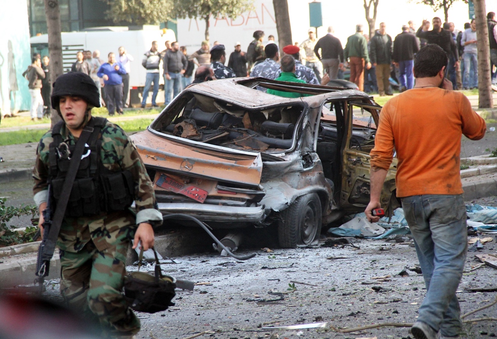 a lebanese soldier walks away from a destroyed taxi cab at the scene of a carbomb explosion that rocked central beirut on december 27 2013 killing an adviser to former anti syria coalition prime ministers saad hariri and fuad siniora and sending plumes of black smoke scudding across the skyline of the lebanese capital photo afp