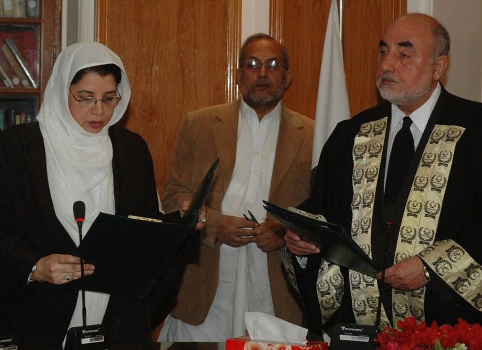 pakistan federal shairat court chief justice agha rafiq ahmed receives an oath from justice ashraf jehan as she becomes the first female judge of the shariah court photo afp