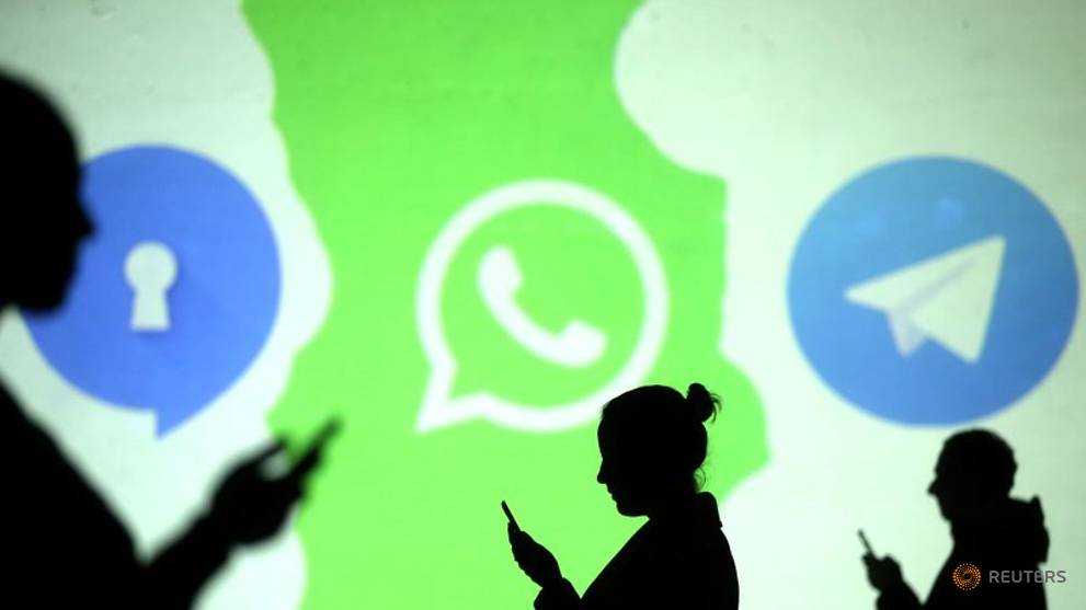 silhouettes of mobile users are seen next to logos of social media apps signal whatsapp and telegram projected on a screen in this picture illustration taken march 28 2018 photo reuters