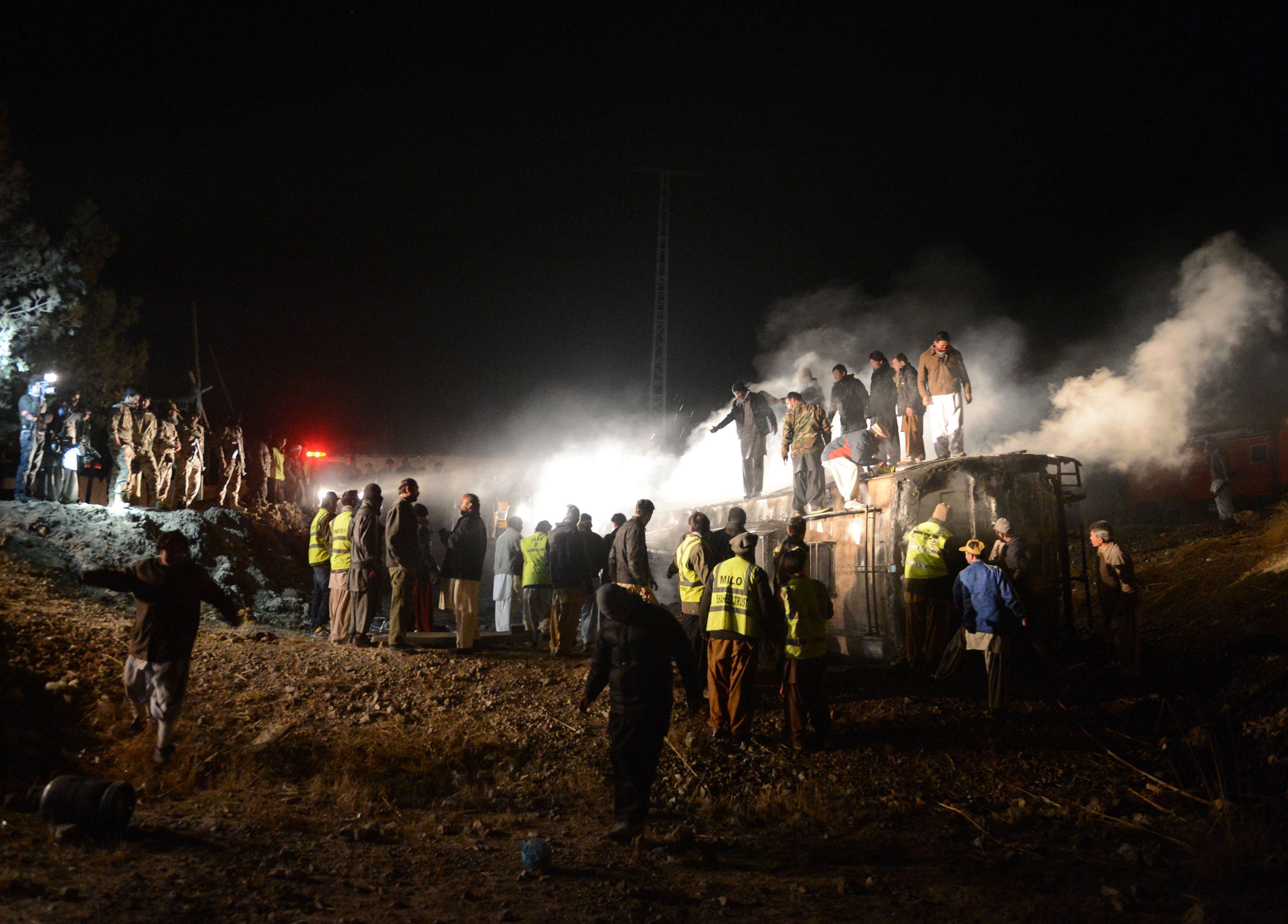 pakistani rescuers and security personnel gather around a burnt passenger bus carrying shia pilgrims at the site of the suicide car bomb attack in akhtarabad on the outskirts of quetta the capital of baluchistan province on january 1 2013 photo afp