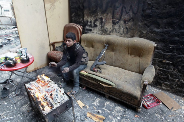 a free syrian army fighter warms himself by a fire on the frontline of old aleppo december 25 2013 photo reuters