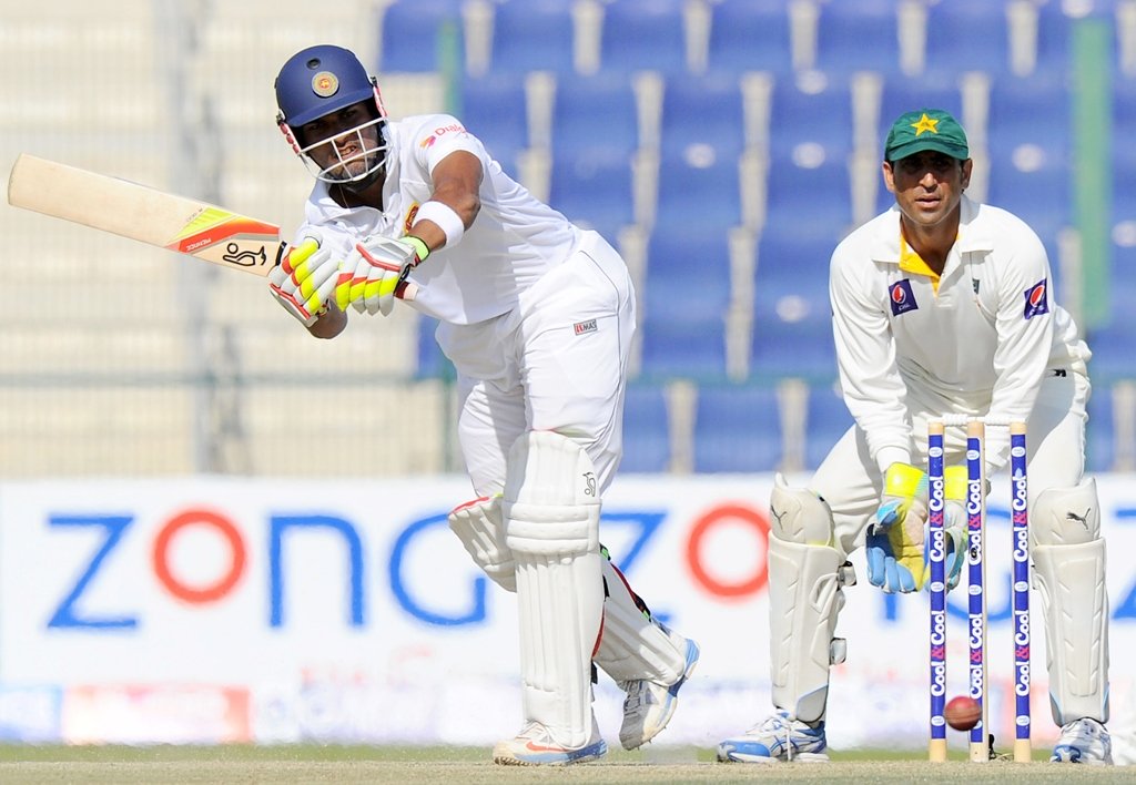 sri lankan batsman dinesh chandimal l plays a shot as pakistan wicketkeeper younis khan r looks on during the fourth day of the first cricket test match between pakistan and sri lanka at the sheikh zayed stadium in abu dhabi on january 3 2014 photo afp