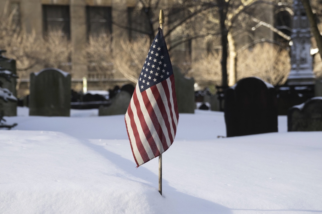 snow lies around the us national flag at trinity church cemetery during a winter storm in new york january 3 2014 photo reuters