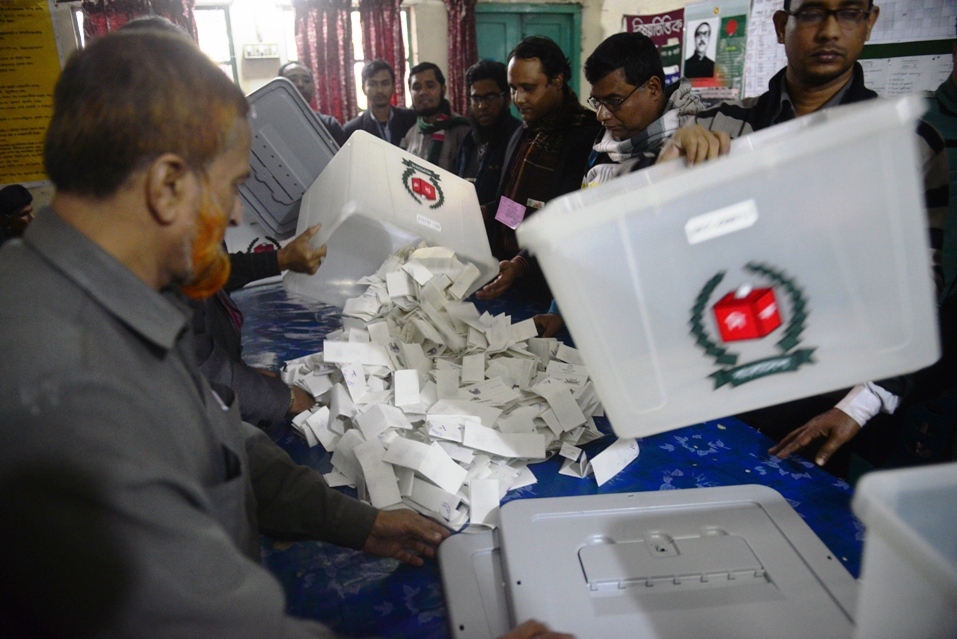 bangladeshi election officials open a ballot box to count votes after polls closed in a polling station in dhaka on january 5 2014 photo afp