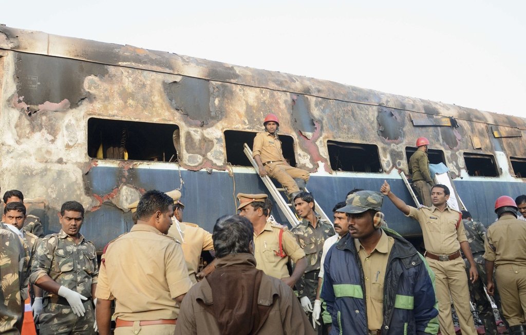 police gather next to a burnt coach after a fire broke out on a train at kothacheruvu town in anantapur district in the southern indian state of andhra pradesh photo reuters