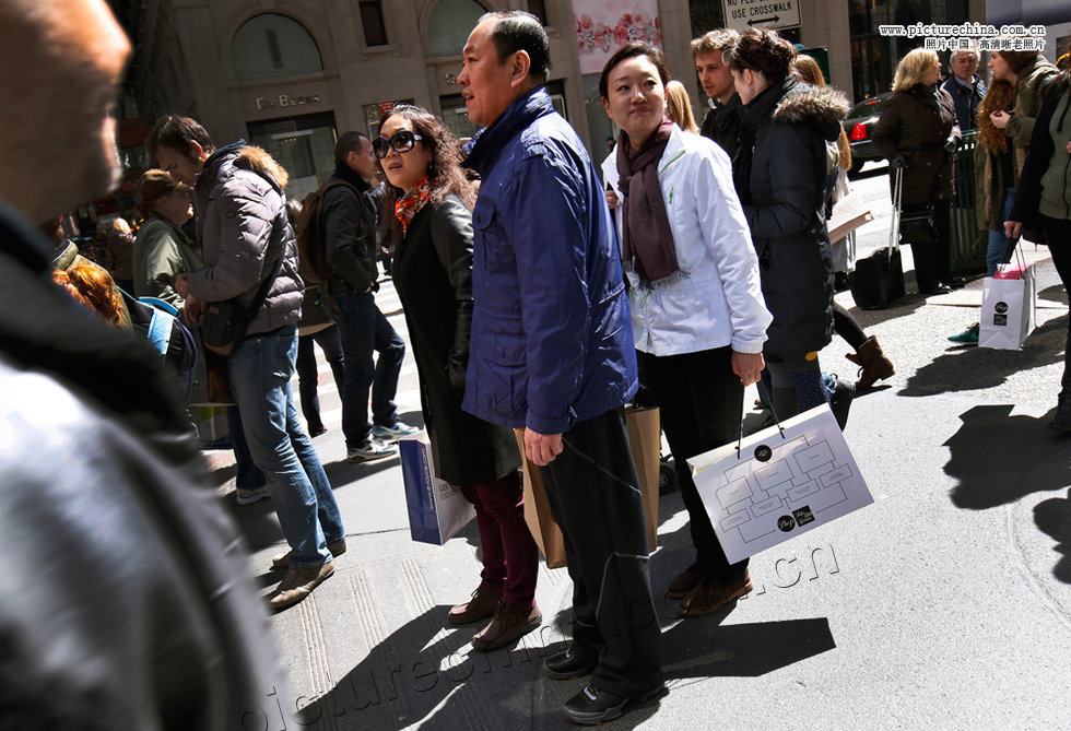 chinese shoppers stand with shopping bags on a sidewalk along 5th avenue in new york photo reuters file