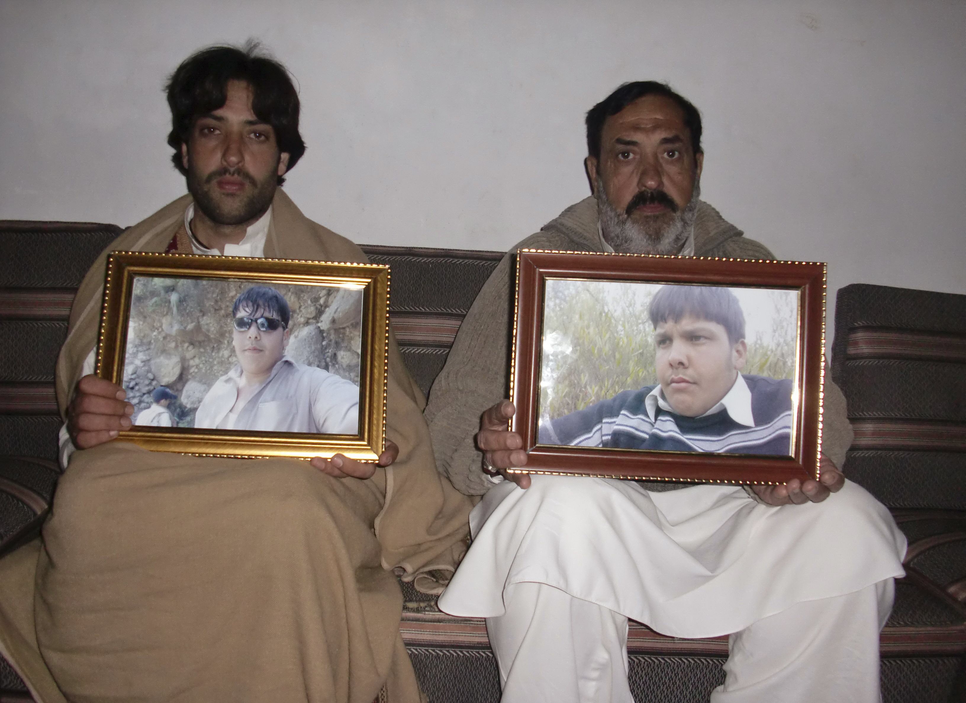 mujahid ali r and mujtaba hasan the father and brother respectively of aitizaz hasan pose for the camera with framed pictures of hassan at their residence in hangu district bordering north waziristan january 10 2014 photo reuters