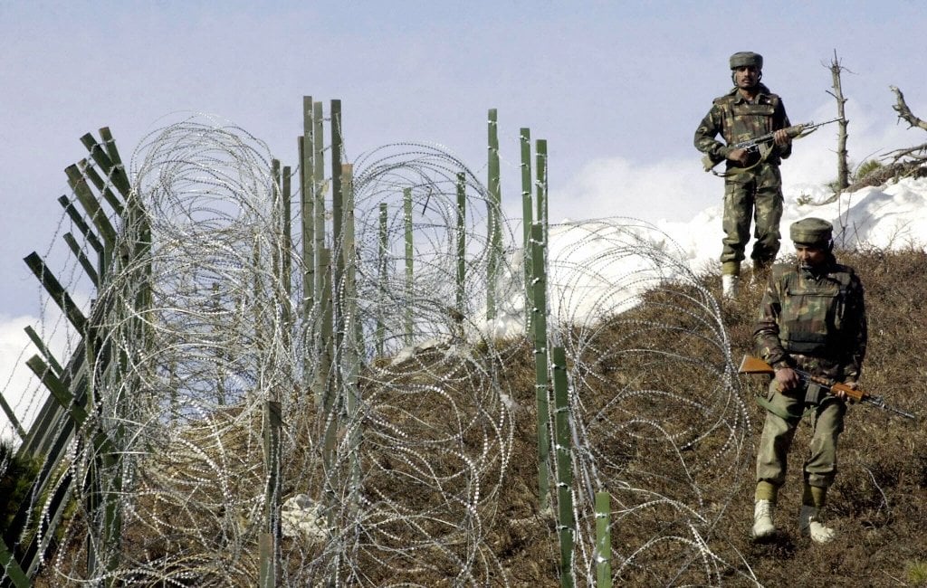 indian soldiers patrol along a barbed wire fence on the line of control photo afp