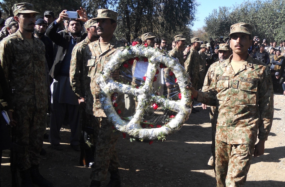 members of the pakistani army ceremonial guard place a wreath of flowers on the grave of student aitzaz hassan in hangu photo afp