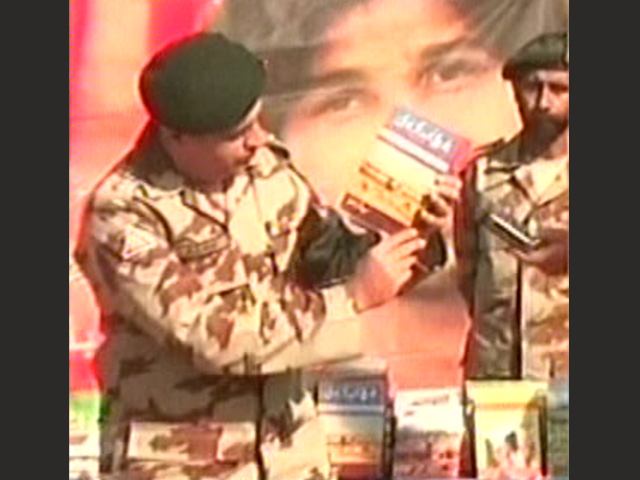 express news screengrab of a frontier corps spokesperson displaying some of the material recovered during the raid