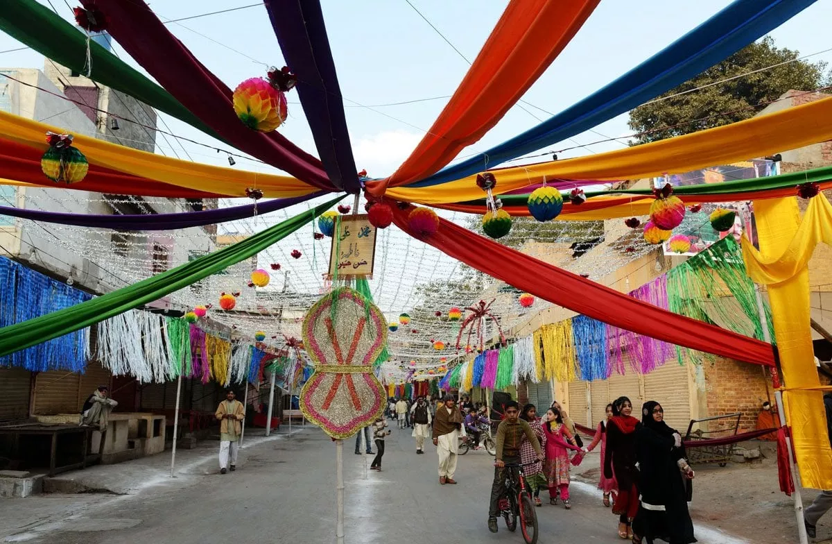 people walk along a street decorated for celebrations marking eid miladun nabi pbuh in lahore on january 14 2014 photo afp people walk along a street decorated for celebrations marking eid miladun nabi pbuh in lahore on january 14 2014 photo afp