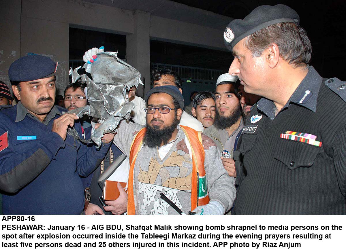 a police official showing sharpnel to media persons after explosion at the tableeghi markaz on charsadda road in peshawar photo app