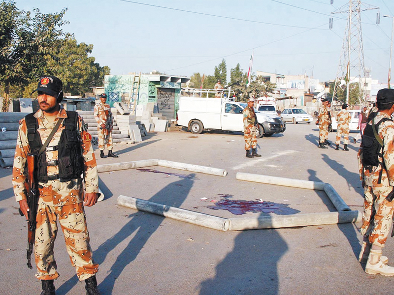 rangers personnel stand guard at the scene of the attack on a police mobile the crossfire resulted in the death of two policemen and the injury of another a separate pool of blood revealed injuries to the assailants as well photo online