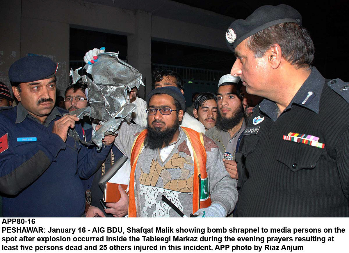 a police officer showing bomb sharpnel after the explosion at the tableghi markaz in peshawar on january 16 2014 photo app