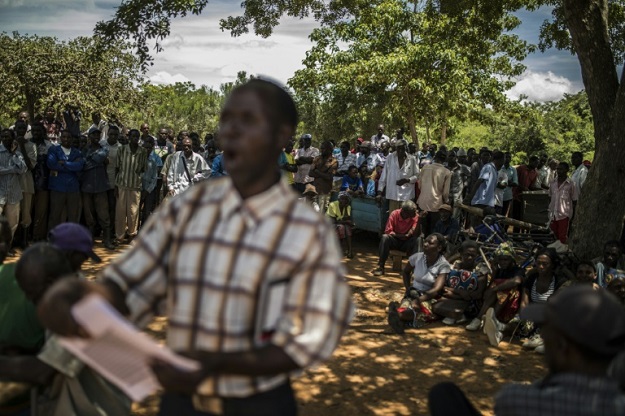 A volunteer reads a list of people who will receive food aid. PHOTO: AFP