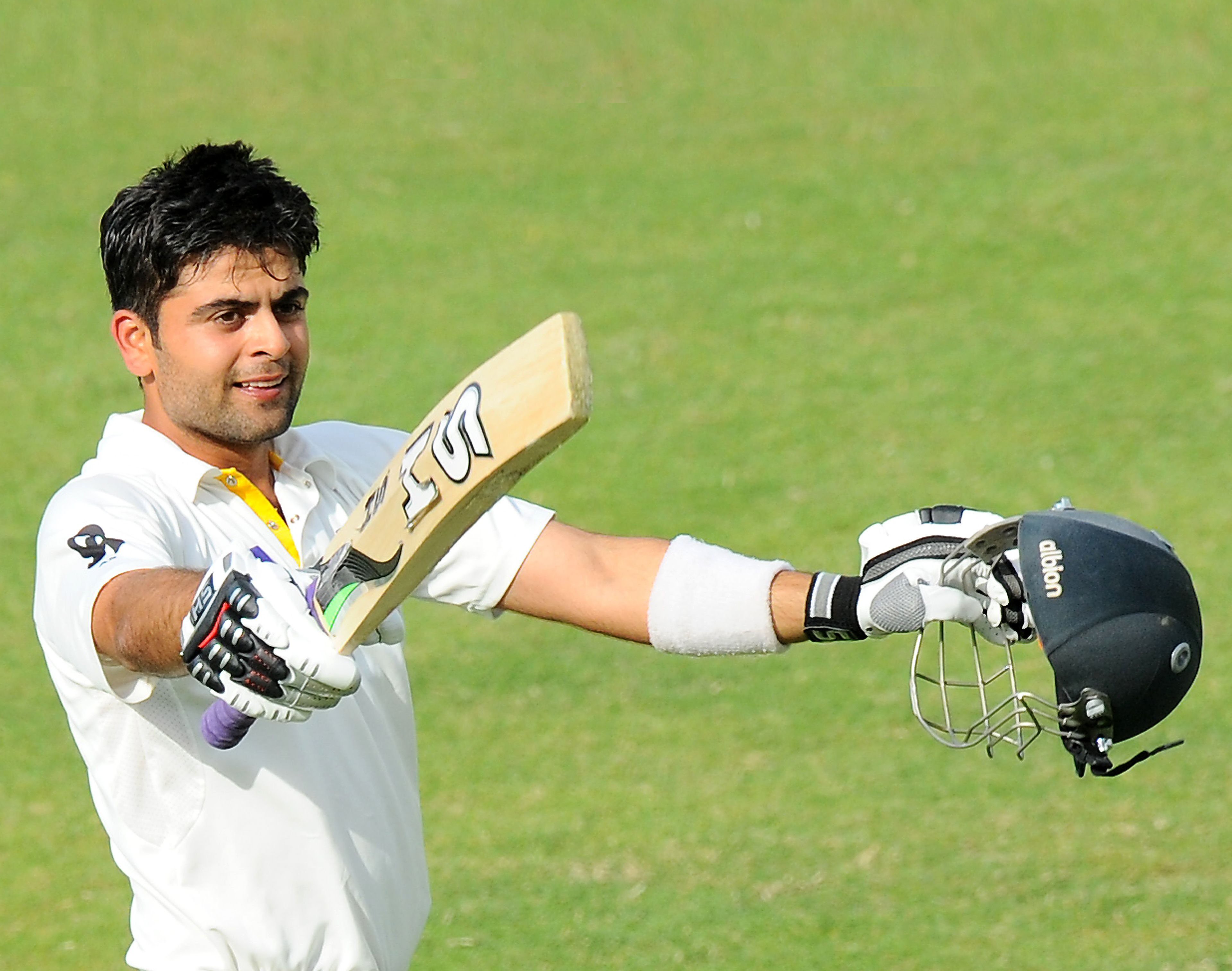 ahmed shehzad raises his bat and helmet in celebration after scoring a century 100 runs during the third day of the third and final cricket test match between pakistan and sri lanka at the sharjah international cricket stadium in the gulf emirate of sharjah on january 18 2014 photo afp