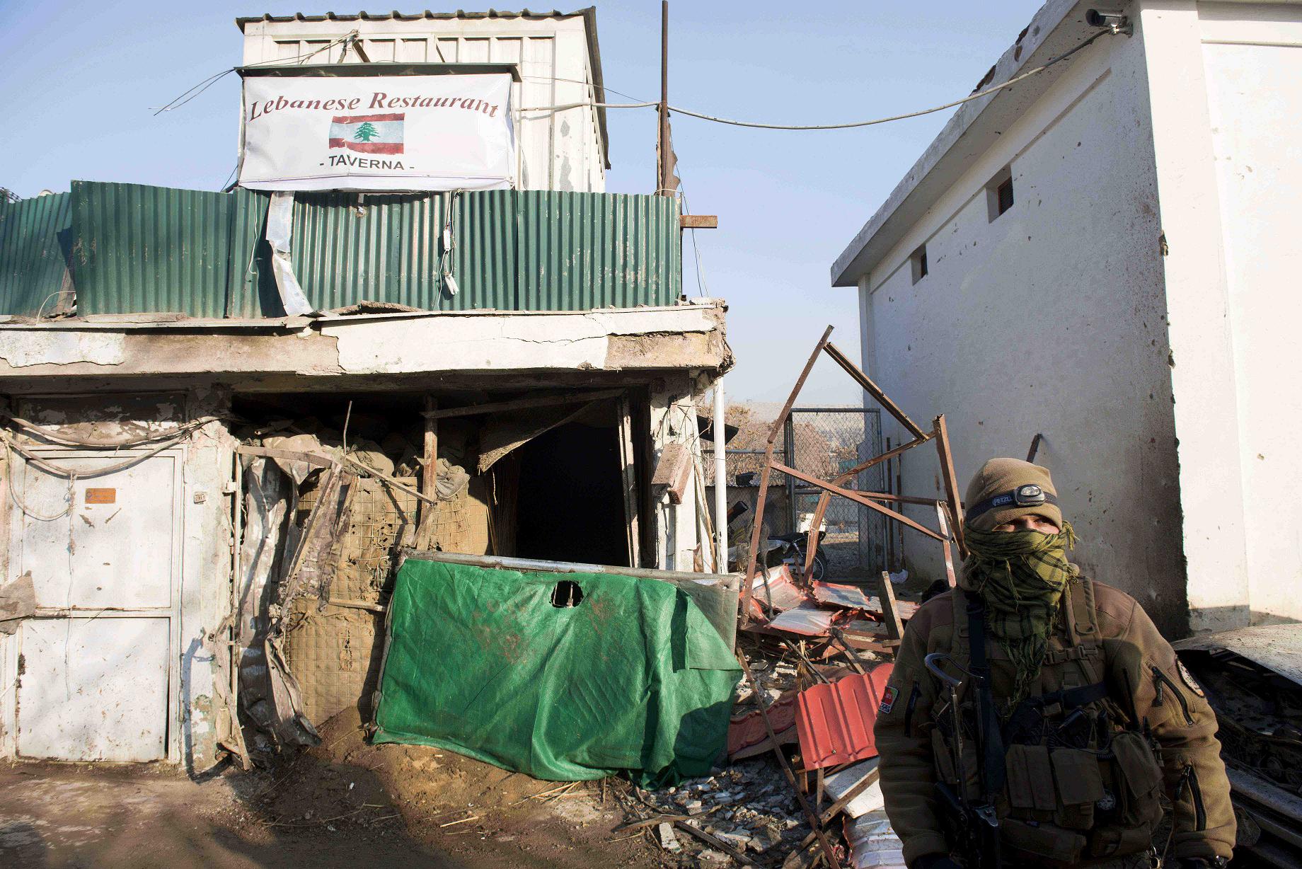 an afghan special force soldier stands guard next to the damaged entrance of a lebanese restaurant that was attacked in kabul on january 18 2014 photo afp