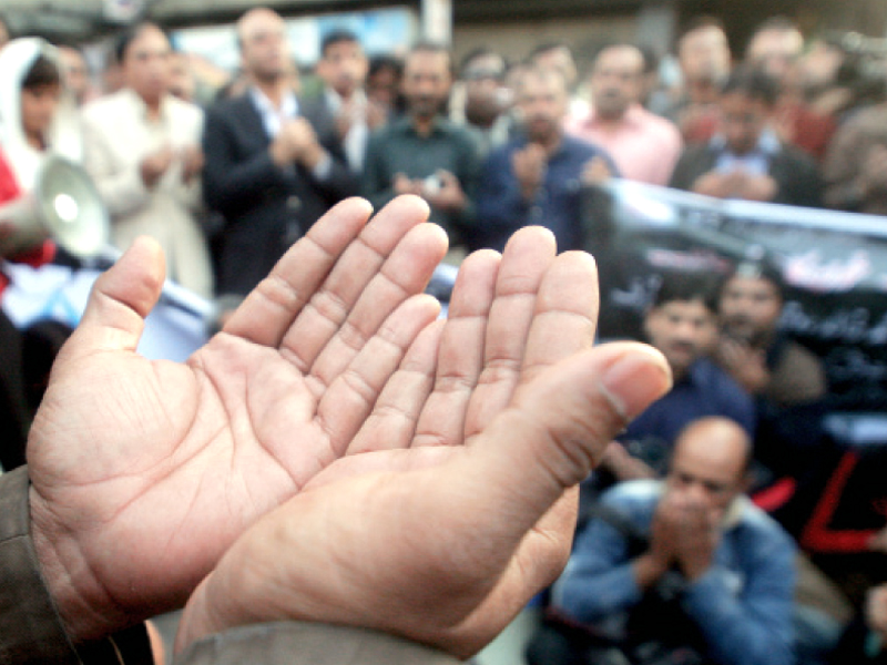 protesters pray for the three express news staff members who lost their lives on january 17 the killings sparked demonstrations throughout the province photo athar khan express