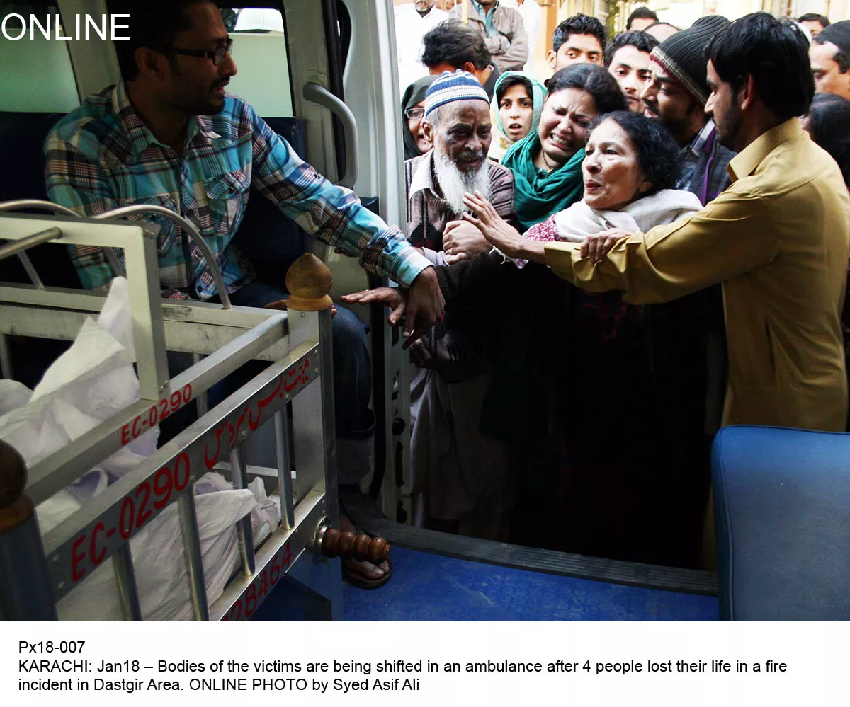 emergency workers bring the dead bodies of those burnt to death in a fire in karachi early on saturday morning photo online emergency workers bring the dead bodies of those burnt to death in a fire in karachi early on saturday morning photo online