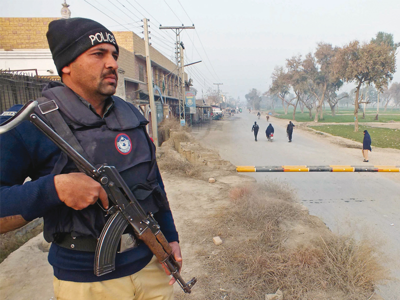 a policeman stands guard near the site of a bomb attack in bannu photo afp