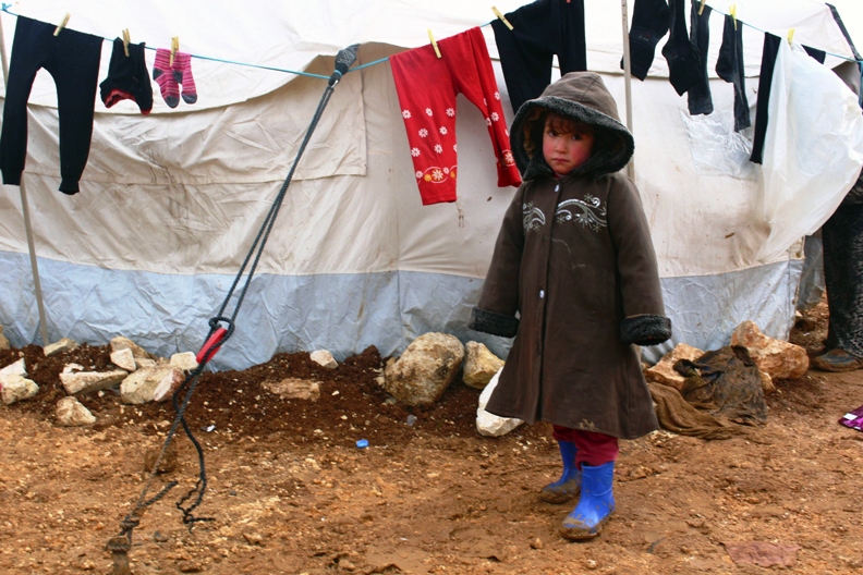 a young syrian refugee poses beside a clothing line at the bab al salam refugee camp in azaz near the syrian turkish border january 17 2014 photo reuters