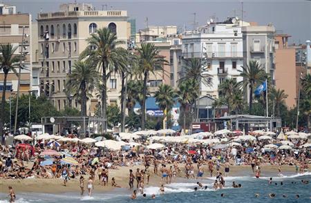 spanish tourism thrives as people relax along barceloneta beach in barcelona photo reuters