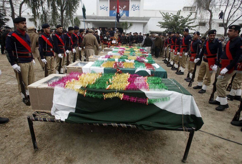 policemen stand guard near the caskets of their colleagues who were killed in a bomb attack during a funeral ceremony at the police line or the police 039 s main office in charsadda on the outskirts of peshawar january 22 2014 photo reuters