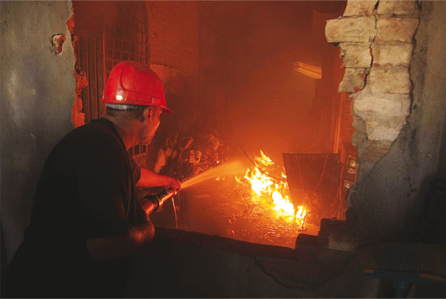 a fireman tries to extinguish a factory fire on tuesday september 11 2012 in lahore photo reuters