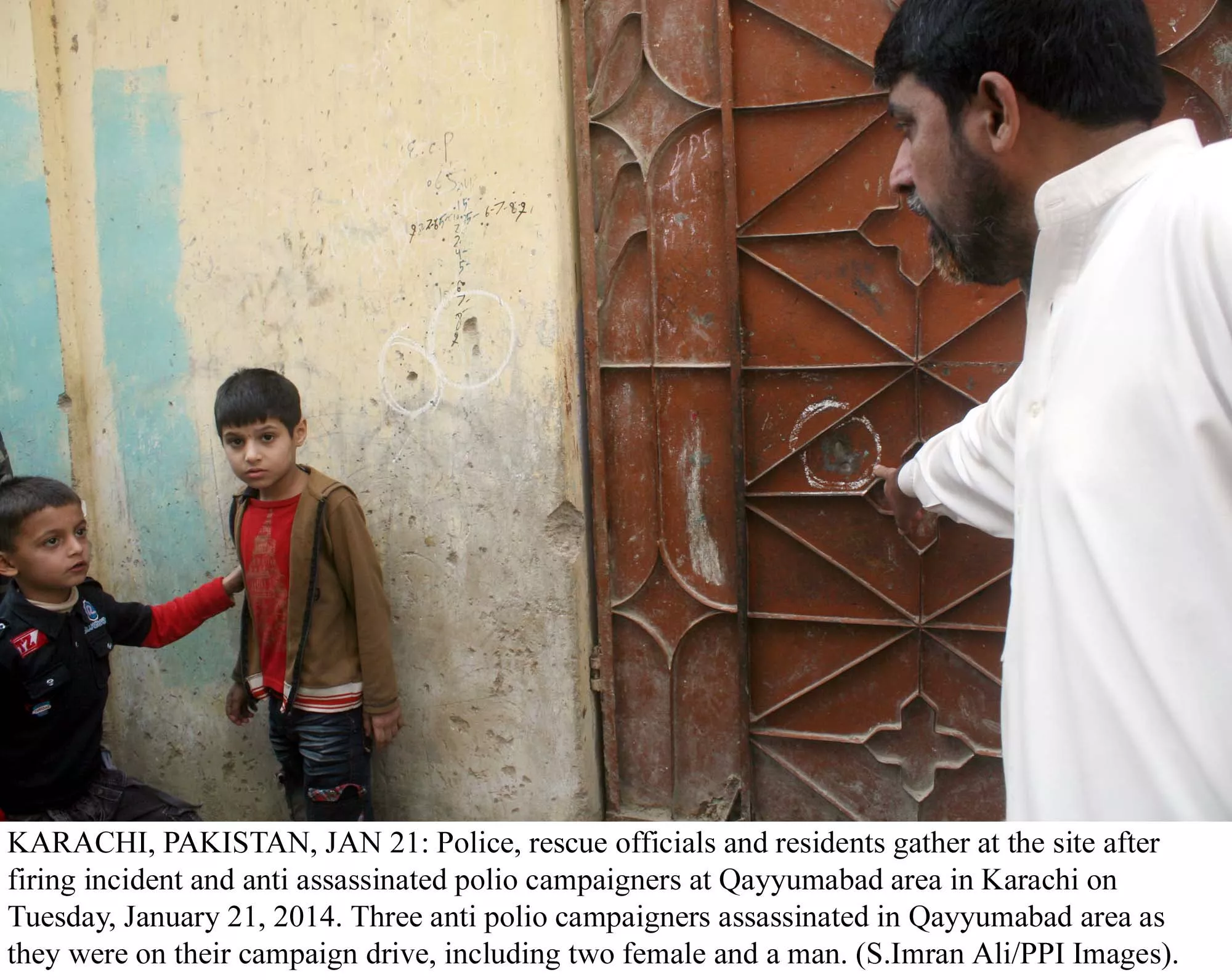 an official points to wards a bullet hole caused by the firing on polio workers in karachi on tuesday as two children look on photo ppi an official points to wards a bullet hole caused by the firing on polio workers in karachi on tuesday as two children look on photo ppi