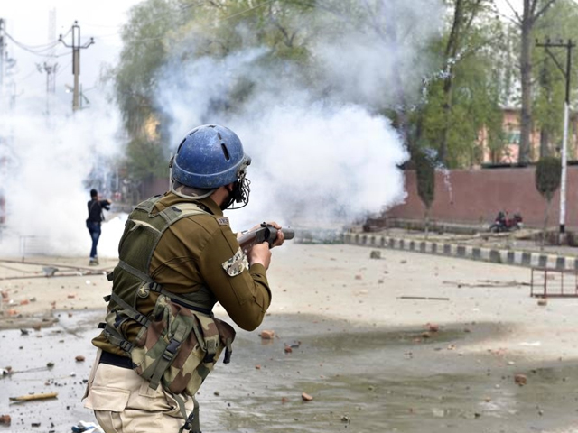 policeman firing tear gas at protesting students of amar singh degree college outside their college while protesting after four days of shutdown over the shopian killing on april 5 2018 in srinagar india photo getty