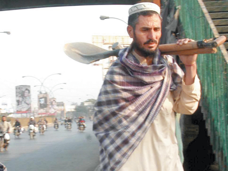 a man looking for work walks dejectedly while holding a spade most labourers were forced to go back empty handed due to the strike on friday photo rashid ajmeri express