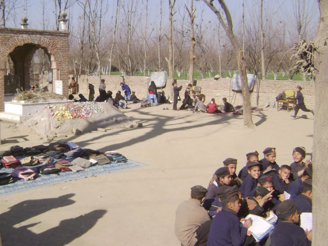 students sit on the ground next to a grave as they take their lessons under the open sky photo ahtisham khan express students sit on the ground next to a grave as they take their lessons under the open sky photo ahtisham khan express