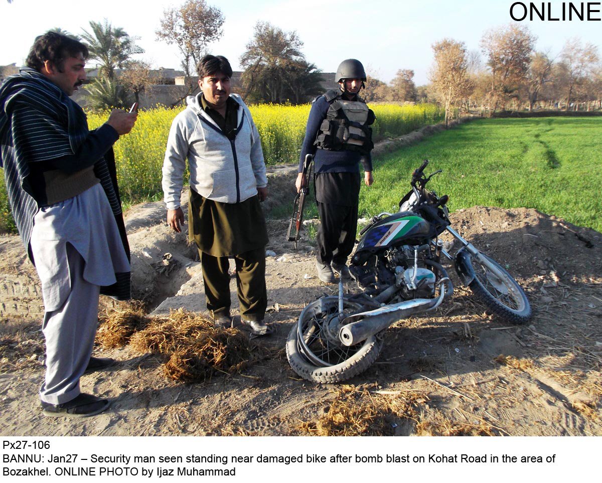 security officials inspect the motorcycle that was blown up on kohat road on monday photo online