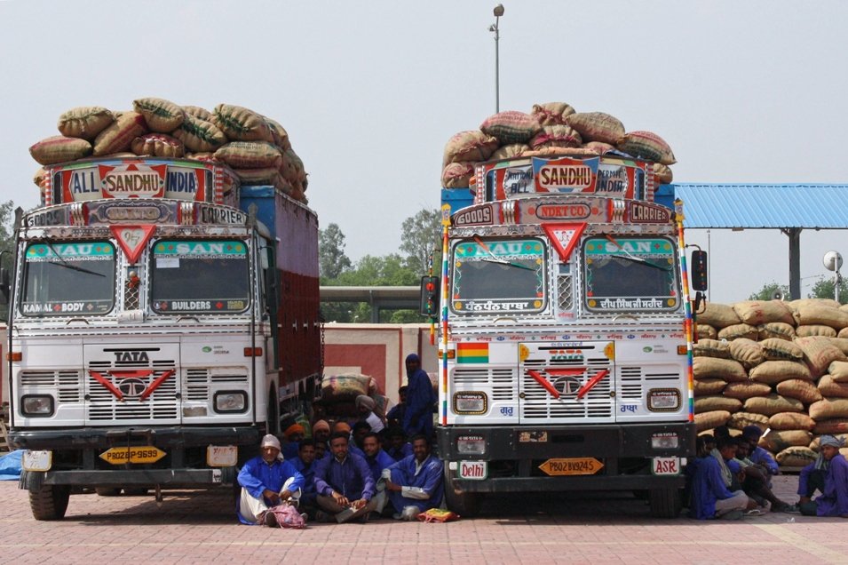 in this file photo indian porters sit under the shade of goods trucks as they stage a sit in protest at the integrated check post icp at the india pakistan border in wagah on april 23 2013 photo afp