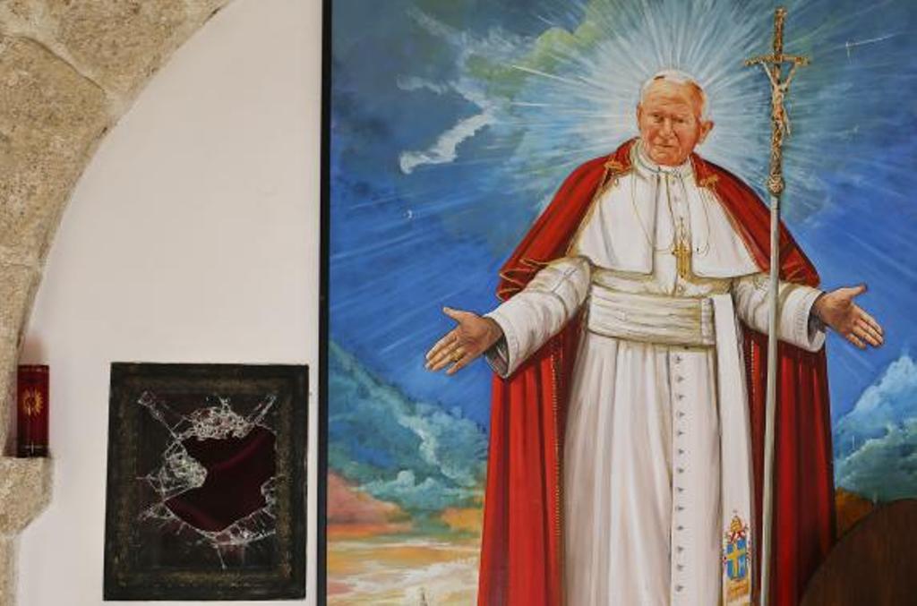 a broken glass of a niche where the reliquary with the blood of the late pope john paul ii was located is seen next to a painting of the late pope in the small mountain church of san pietro della ienca near the city of l 039 aquila january 28 2014 photo reuters