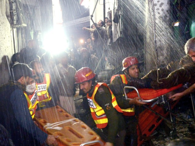 volunteers remove victims from the site of the suicide bombing in peshawar photo afp
