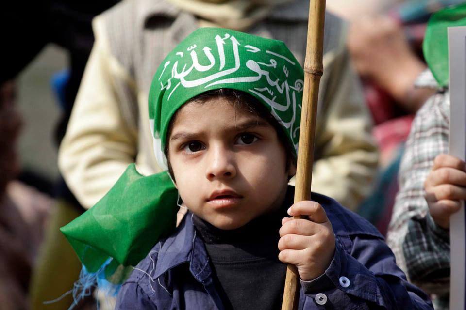 a child with a flag wrapped around his head on kashmir solidarity day in lahore photo shafiq malik