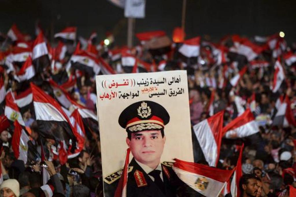 supporters of egypt 039 s army chief general abdel fattah al sisi holds a poster of sisi in tahrir square in cairo on the third anniversary of egypt 039 s uprising january 25 2014 photo reuters