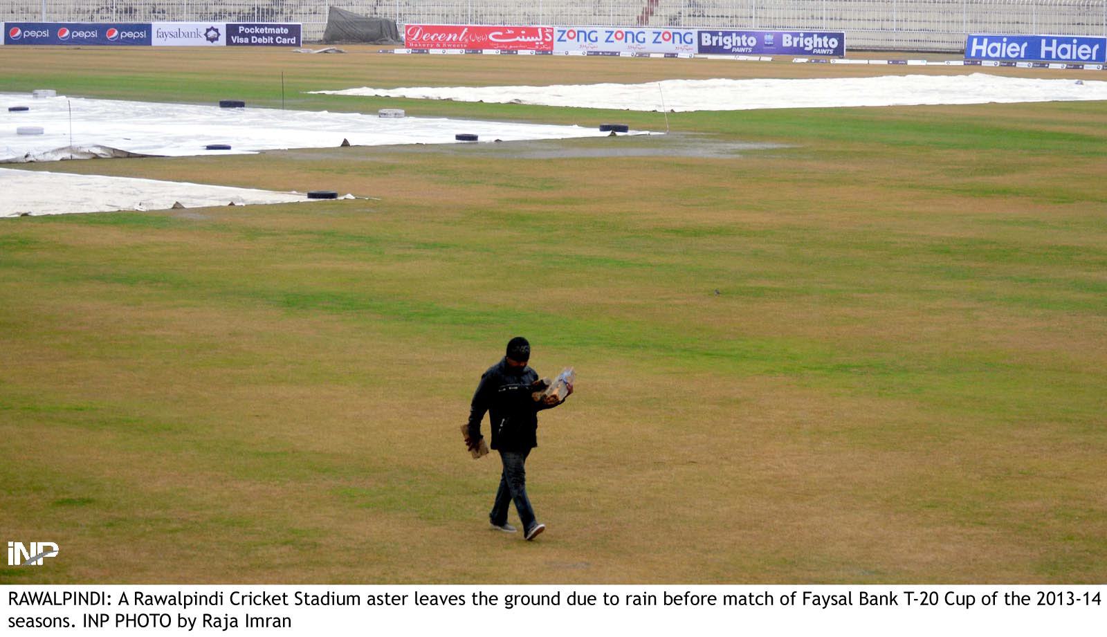 a man walks off the rawalpindi cricket ground after rain forced matches in the faysal bank twenty20 tournament to be abandoned on thursday photo inp