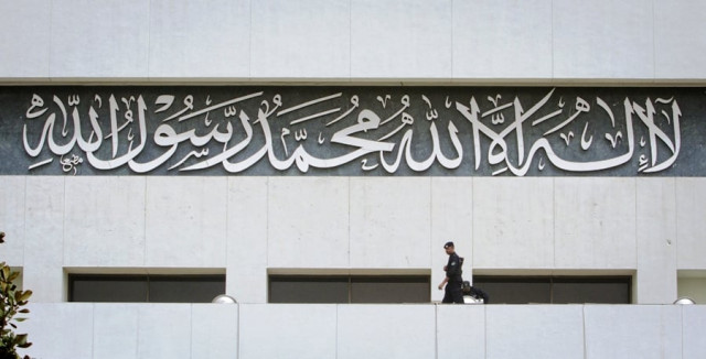 a policeman keeps guard near an inscription written on the parliament building in islamabad march 20 2012 photo reuters a policeman keeps guard near an inscription written on the parliament building in islamabad march 20 2012 photo reuters