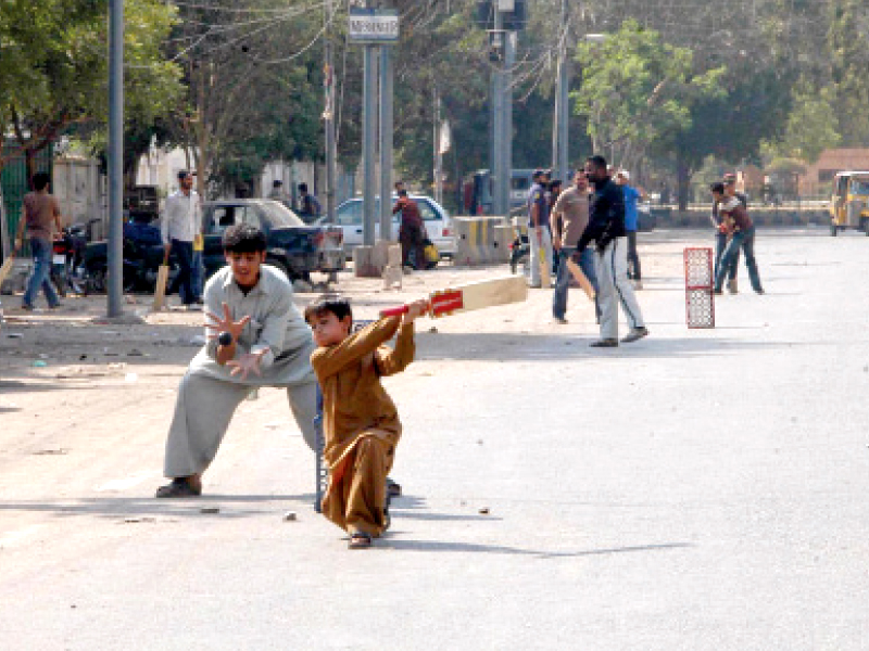 making most of the deserted streets on saturday due to the strike called by mqm children and men keep themselves busy in cricket photo mohammad saqib express